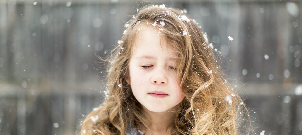 girl with eyes closed and snowflakes