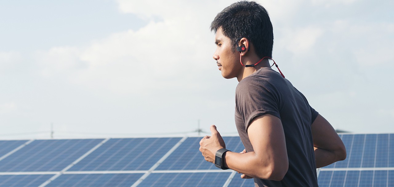 Cardio runner running listening smartphone music in a solar power plant. Sporty fit young man jogging,Exercising, fitness and healthy lifestyle concept; Shutterstock ID 685095568; PO: 123