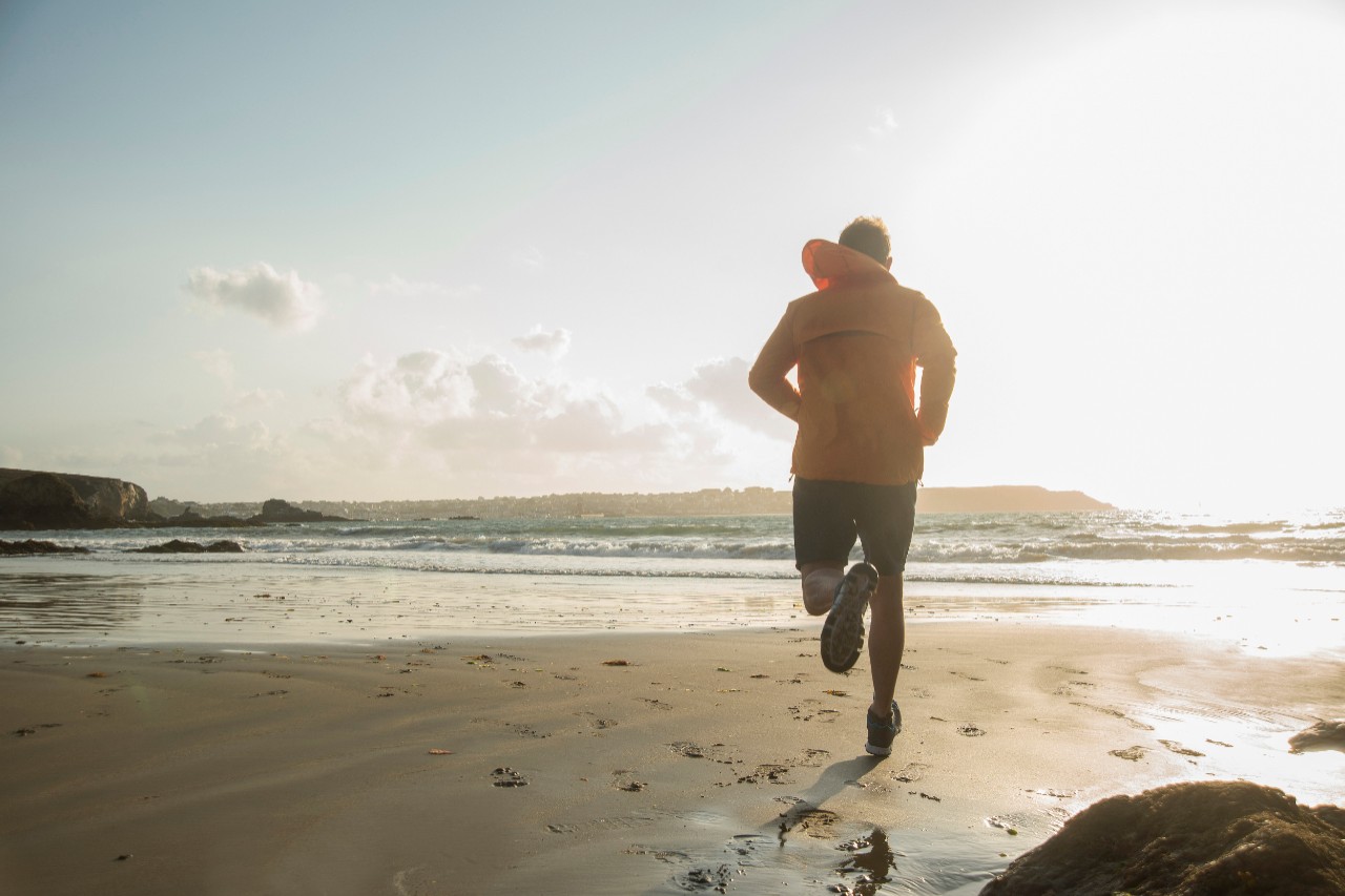 10 Aug 2014, Camaret-sur-Mer, France --- Mature man running on sand, along coastline --- Image by © Uwe Umstaetter/Corbis