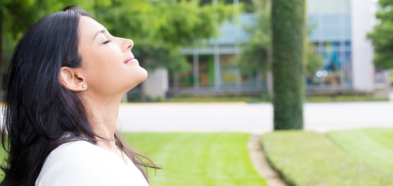 Closeup portrait, young woman in white shirt breathing in fresh crisp air after long day of work, isolated outdoors outside background. Stop and smell the roses, connect with nature; Shutterstock ID 435747925; PO: 123