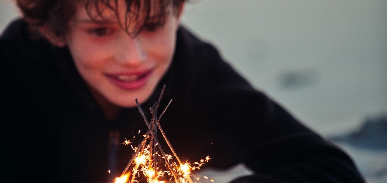 Boy thrilled with the effect of lighting multiple sparklers at once