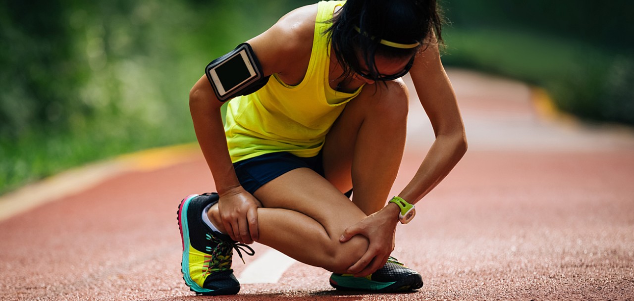 Female runner suffering with pain on sports running knee injury